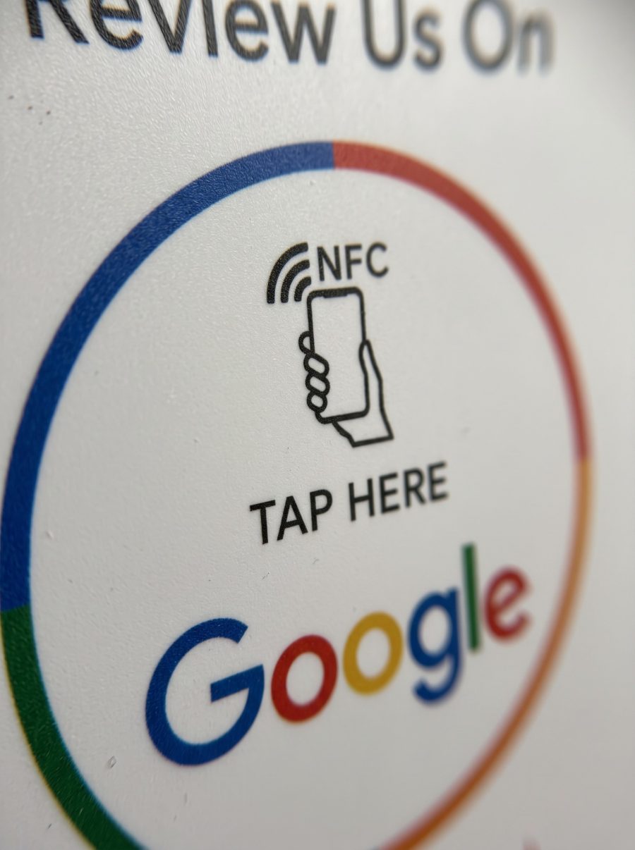 Primer plano del soporte: el icono de NFC con un móvil, el texto TAP HERE y el logotipo de Google