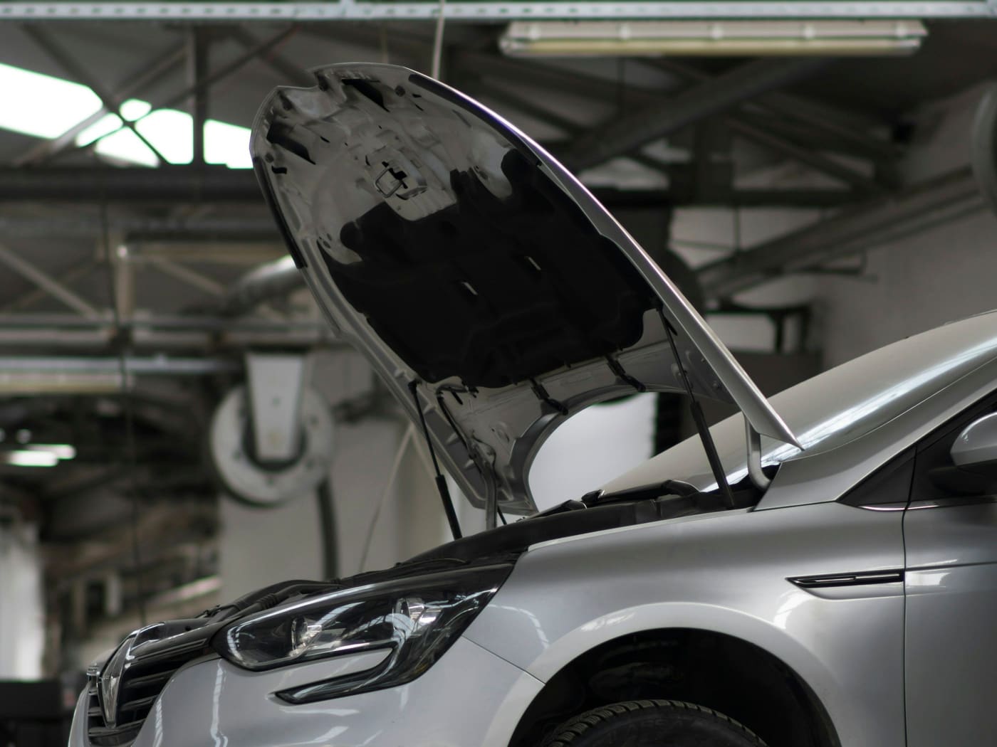 Coche sobre uno de los cuatro elevadores de la zona de mecánica